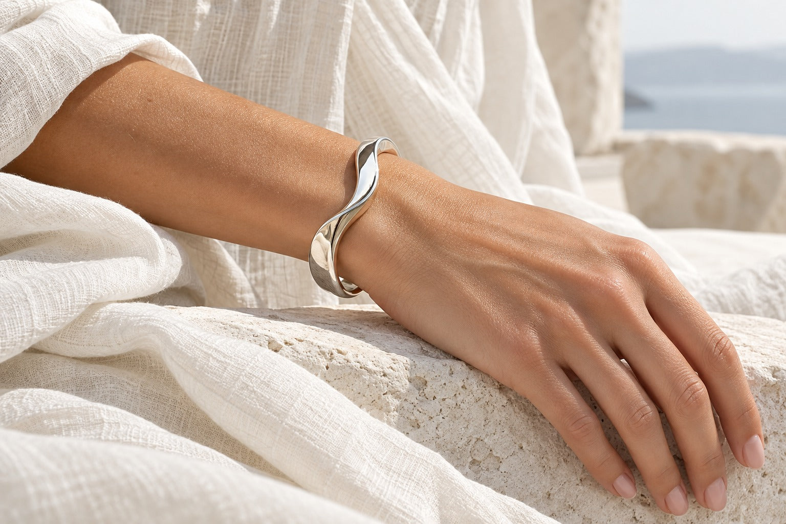 Silver-tone wave cuff worn with ivory linen